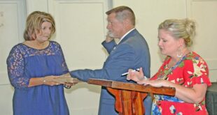 Sheila Harrelson holds Todd’s grandmother’s Bible as Todd Harrelson repeats the oath of office that Kenya Wright administers.