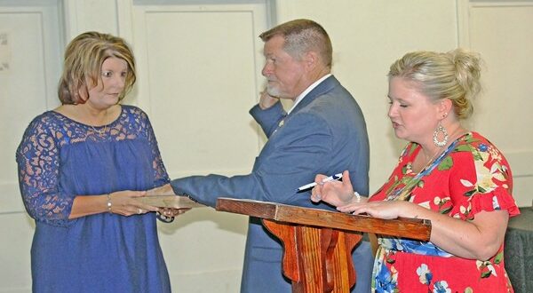 Sheila Harrelson holds Todd’s grandmother’s Bible as Todd Harrelson repeats the oath of office that Kenya Wright administers.